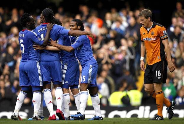 Florent Malouda (R) of Chelsea celebrates scoring his side s first goal with his teammates while a dejected Christophe Berra of Wolverhampton Wanderers looks on - Barclays Premier League Chelsea FC (blue) v Wolverhampton Wanderers (orange) 23rd October, 2010 EDITORIAL USE ONLY. No use with unauthorised audio, video, data, fixture lists, club league logos or live services. Online in-match use limited to 120 images, no video emulation. No use in betting, games or single club league player publications.