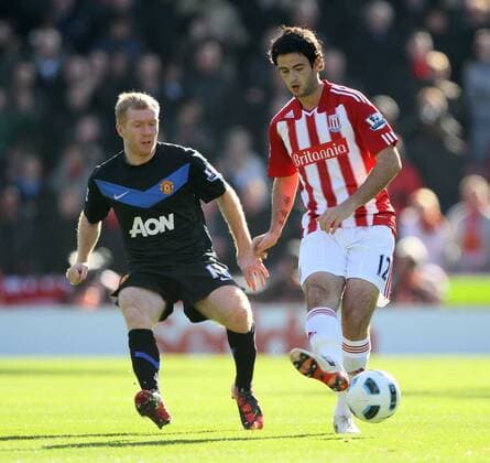 Stokes Marc Wilson tussles with Manchester Uniteds Paul Scholes --- Barclays Premier League - Stoke City (red stripes) vs Manchester United (ManU black), 24th October, 2010 EDITORIAL USE ONLY. No use with unauthorised audio, video, data, fixture lists, club league logos or live services. Online in-match use limited to 120 images, no video emulation. No use in betting, games or single club league player publications.