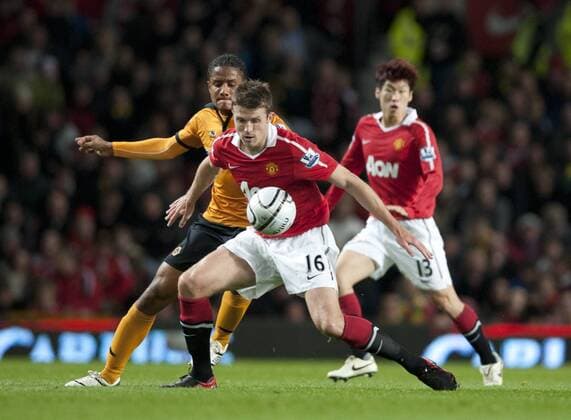 Michael Carrick of Manchester United (ManU red) holds off Michael Mancienne of Wolverhampton Wanderers (orange) Carling Cup Manchester United v Wolverhampton Wanderers 26th October, 2010 EDITORIAL USE ONLY. No use with unauthorised audio, video, data, fixture lists, club league logos or live services. Online in-match use limited to 120 images, no video emulation. No use in betting, games or single club league player publications.