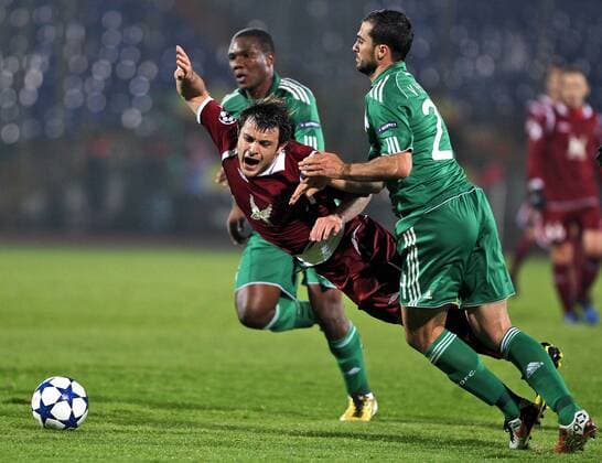 KAZAN, RUSSIA. NOVEMBER 2, 2010. Rubin s Alan Kasaev (in red) and Panathinaikos Simao and Loukas Vintra (in green, L to R) seen during an UEFA Champions League match between Rubin Kazan and Panathinaikos Athens. The match ends in a 0-0 draw.  RE0DB103