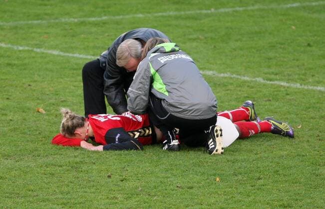 Duisburg, Champions-League, FCR Duisburg - Fortuna Hjörring. Alexandra Popp (Duisburg) liegt verletzt am Boden und wird behandelt. o0 Verletzung, Betreuer