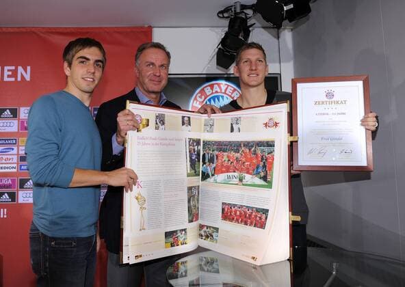 Fussball 1. Bundesliga: Saison 2010 2011, 10.11.2010 Der FC Bayern Muenchen praesentiert die 30kg schwere Vereinschronik (v.li) Philipp Lahm, Vorstandsvorsitzender Karl Heinz Rummenigge, Bastian Schweinsteiger (FC Bayern Muenchen) 