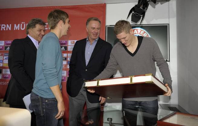10.11.2010, Fussball 1.Bundesliga 2010 2011, FC Bayern München präsentiert die neue Vereins-Chronik. Das 30 Kg schwere Buch gibt es nur in 4111 Exemplaren und kostet ca 3000,- Euro. Bei der Buchvorstellung präsent: v.li: Philipp Lahm (Bayern München), Vorstandsvorsitzender Karl-Heinz Rummenigge (München), Bastian Schweinsteiger (München) der das Buch versucht hochzuheben.
