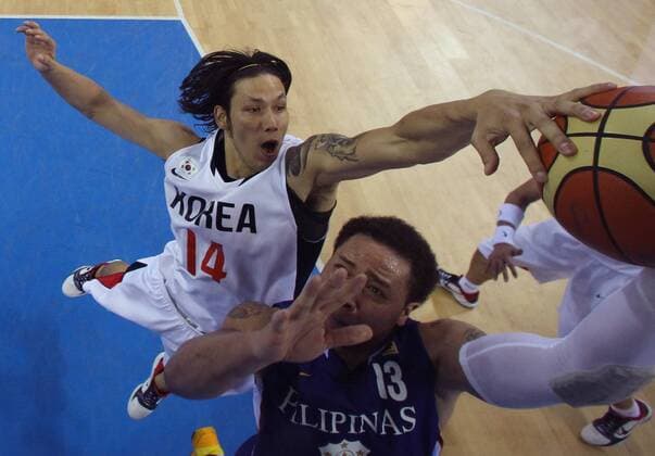 (101124) -- GUANGZHOU, Nov. 24, 2010 (Xinhua) -- South Korea s Lee Seung Jun(L) blocks the ball during the men s quarterfinal of basketball against Philippines at the 16th Asian Games in Guangzhou, south China s Guangdong Province, Nov. 24, 2010. South Korea won 74-66 to enter the semifinal match. (Xinhua Meng Yongmin) CHINA-GUANGZHOU-16TH ASIAN GAMES-BASKETBALL (CN) 