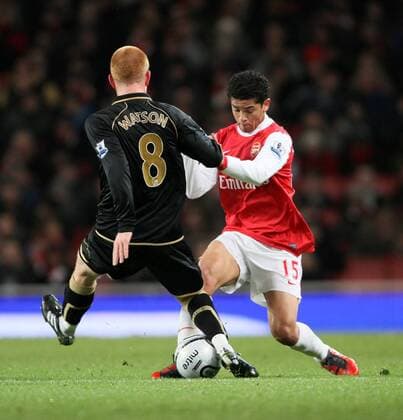 Arsenals Denilson r. tussles with Wigans Ben Watson Carling Cup quarter final Arsenal FC London vs Wigan Athletic 30th November, 2010 EDITORIAL USE ONLY. No use with unauthorised audio, video, data, fixture lists, club league logos or live services. Online in-match use limited to 120 images, no video emulation. No use in betting, games or single club league player publications.