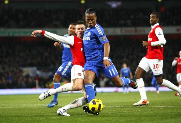 Didier Drogba of Chelsea FC is tackled by Laurent Koscielny of Arsenal - Barclays Premier League, Arsenal (red) v Chelsea FC 27th December, 2010 EDITORIAL USE ONLY. No use with unauthorised audio, video, data, fixture lists, club league logos or live services. Online in-match use limited to 120 images, no video emulation. No use in betting, games or single club league player publications.
