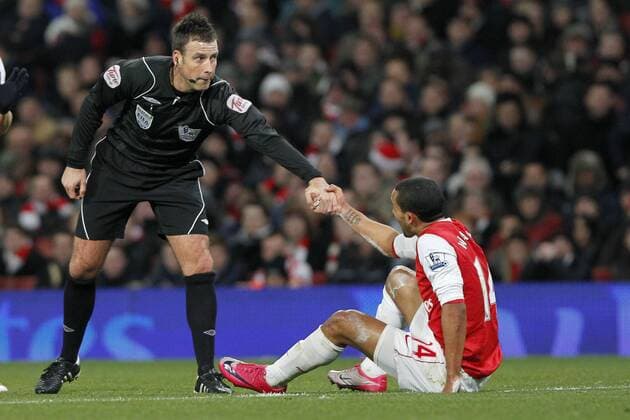 Football - Premiership - Arsenal (red) vs. Chelsea FC: Referee, Mark Clattenburg helps up Arsenal s Theo Walcott at The Emirates Stadium, London 