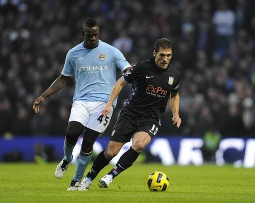 Stiliyan Petrov of Aston Villa chased by Mario Balotelli of Manchester City - Barclays Premier League, Manchester City (Blue) v Aston Villa (black) 28th December, 2010 EDITORIAL USE ONLY. No use with unauthorised audio, video, data, fixture lists, club league logos or live services. Online in-match use limited to 120 images, no video emulation. No use in betting, games or single club league player publications.