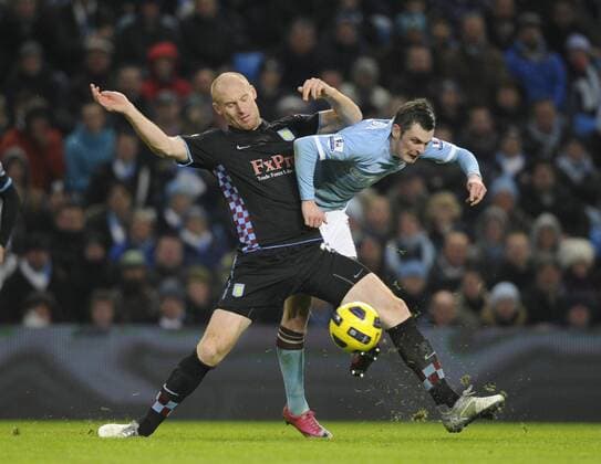 James Collins (L) of Aston Villa challenges Adam Johnson of Manchester City - Barclays Premier League, Manchester City (Blue) v Aston Villa (black) 28th December, 2010 EDITORIAL USE ONLY. No use with unauthorised audio, video, data, fixture lists, club league logos or live services. Online in-match use limited to 120 images, no video emulation. No use in betting, games or single club league player publications.