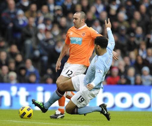 Joleen Lescott of Manchester City (blue) tackles Gary Taylor Fletcher of Blackpool --- Barclays Premier League 2010 2011 - Manchester City (blue) vs FC Blackpool (orange), 1st January, 2011 EDITORIAL USE ONLY. No use with unauthorised audio, video, data, fixture lists, club league logos or live services. Online in-match use limited to 120 images, no video emulation. No use in betting, games or single club league player publications.