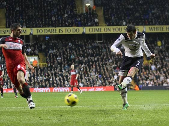 Tottenhams Gareth Bale fires in a shot against Fulhams Aaron Hughes --- Barclays Premier League 2010 2011 - Tottenham Hotspur (white) vs FC Fulham (red), 1st January, 2011 EDITORIAL USE ONLY. No use with unauthorised audio, video, data, fixture lists, club league logos or live services. Online in-match use limited to 120 images, no video emulation. No use in betting, games or single club league player publications.