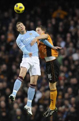Edin Dzeko of Manchester City (L) challenged by Chistophe Berra of Wolverhampton Wanderers - Manchester City - Wolverhampton Wanderers - EDITORIAL USE ONLY. No use with unauthorised audio, video, data, fixture lists, club league logos or live services. Online in-match use limited to 120 images, no video emulation. No use in betting, games or single club league player publications.