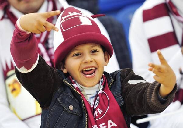 A Qatari boy cheers for the team before the 2011 Asian Cup quarterfinal football match in Doha, capital of Qatar - 