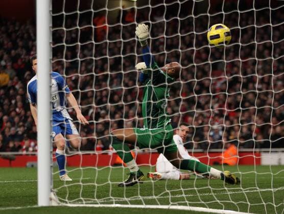 Arsenals Robin Van Persie (R) scoring his second goal as Wigans Ali Al Habsi looks on Barclays Premier League Arsenal v Wigan Athletic 22nd January, 2011 EDITORIAL USE ONLY. No use with unauthorised audio, video, data, fixture lists, club league logos or live services. Online in-match use limited to 120 images, no video emulation. No use in betting, games or single club league player publications.