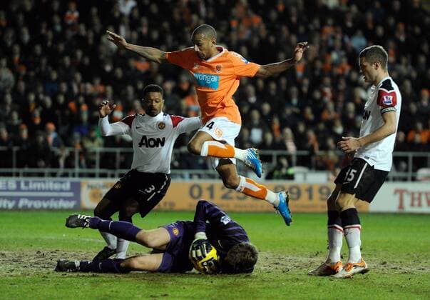 goalkeeper Edwin van der Sar of Manchester United saves at the feet of Elliot Grandin of Blackpool (C) --- Blackpool FC vs. Manchester United EDITORIAL USE ONLY. No use with unauthorised audio, video, data, fixture lists, club league logos or live services. Online in-match use limited to 120 images, no video emulation. No use in betting, games or single club league player publications. o0 Abwehr