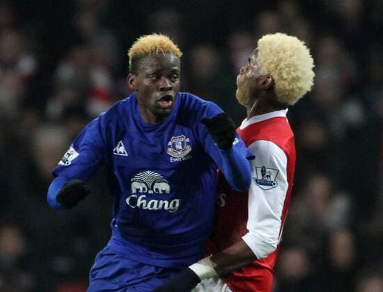 Arsenal FC (red)s Alex Song tussles with Everton FCs Louis Saha in a battle of the bleeched hair Barclays Premier League Arsenal FC (red) v Everton FC 1st February, 2011 EDITORIAL USE ONLY. No use with unauthorised audio, video, data, fixture lists, club league logos or live services. Online in-match use limited to 120 images, no video emulation. No use in betting, games or single club league player publications.
