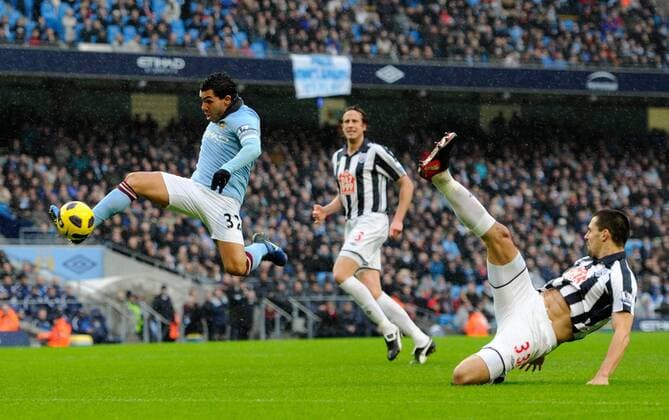 Carlos Tevez of Manchester City (L) breaks free to volley in a shot on goal against Paul Scharner of West Brom (front) --- Manchester City vs. West Bromwich Albion EDITORIAL USE ONLY. No use with unauthorised audio, video, data, fixture lists, club league logos or live services. Online in-match use limited to 120 images, no video emulation. No use in betting, games or single club league player publications.