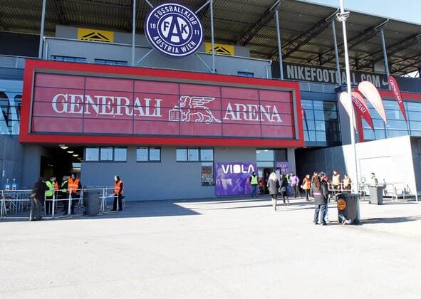 Bild zeigt Fans beim Eingang der Generali Arena, Heimspielstätte des FK Austria Wien  o0 Logo, Emblem, Vereinslogo, Vereinsemblem Schriftzug Sponsor, Werbepartner, Werbung, Wirtschaft