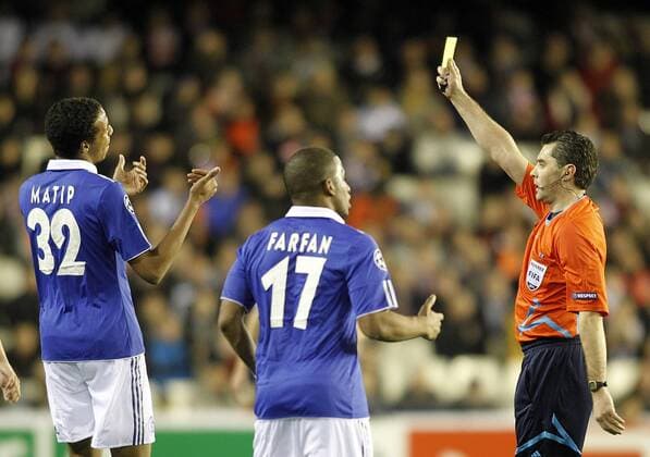 Schalke 04 s Joel Matip (L) gets a yellow card from referee Aleksey Nikolaev (RUS) --- Valencia CF vs. FC Schalke 04  (201102154665)