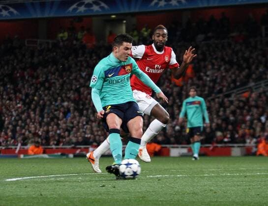 Barcelonas David Villa scoring his sides opening goal vs Johann Djourou --- UEFA Champions League 1st Leg last 16 Arsenal London (red) v FC Barcelona Barca (green) 16th February, 2011 EDITORIAL USE ONLY. No use with unauthorised audio, video, data, fixture lists, club league logos or live services. Online in-match use limited to 120 images, no video emulation. No use in betting, games or single club league player publications.
