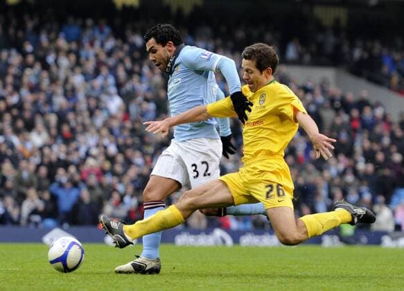 Carlos Tevez of Manchester City (L) holds off the tackle by Jon Harley of Notts County to score the third goal - FA Cup 4th Round replay Manchester City - Notts County - EDITORIAL USE ONLY. No use with unauthorised audio, video, data, fixture lists, club league logos or live services. Online in-match use limited to 120 images, no video emulation. No use in betting, games or single club league player publications.