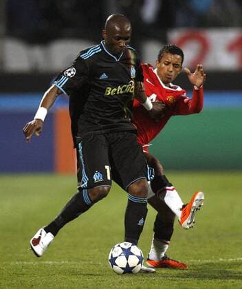 Stephane Mbia of Marseille holds off Nani of Manchester United --- Champions League Round of 16 First Leg - Olympique Marseille (blue) vs. Manchester United ManU (red) --- EDITORIAL USE ONLY. No use with unauthorised audio, video, data, fixture lists, club league logos or live services. Online in-match use limited to 120 images, no video emulation. No use in betting, games or single club league player publications. o0 M bia