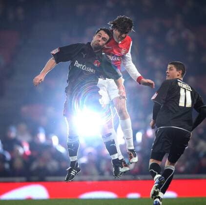 Arsenal FC s Ignasi Miquel tussles with Leyton Orients Scott McGleish as a flash bulb goes off - EON FA Cup 5th Round Replay Arsenal FC (red) v Leyton Orient (black) 2nd March, 2011 EDITORIAL USE ONLY. No use with unauthorised audio, video, data, fixture lists, club league logos or live services. Online in-match use limited to 120 images, no video emulation. No use in betting, games or single club league player publications.