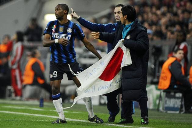 FC Bayern München (rot) vs. Inter Mailand (blau) --- Torjubel Samuel Eto o (li.) gemeinsam mit seinem Teamkollegen Yuto Nagatomo (vorn), der mit einer japanischen Landesfahne der Opfer des Erdbebens in seinem Heimatland gedenkt  o0 Aufmacher Objekte Fahne kurios Kameradschaft Teamgeist