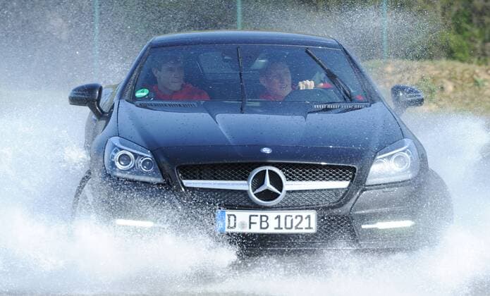 Fahren mit dem Mercedes-Benz SLK 350 BlueEFFICIENCY über die Strecke: Bastian SCHWEINSTEIGER (Deutschland) am Steuer, als Beifahrer: Holger BADSTUBER (Deutschland). Fussball: Driving-Experience Fahrsicherheitstraining der deutschen Fussball Nationalmannschaft der Männer auf der Strecke des ADAC-Fahrsicherheitszentrum in Grevenbroich, 28.03.2011. Poolfoto.