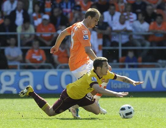 Jack Wilshere of FC Arsenal London (yellow) tackled by Luke Varney of Blackpool FC (orange) --- Barclays Premier League - Blackpool FC (orange) vs FC Arsenal London (yellow) 10th April, 2011 EDITORIAL USE ONLY. No use with unauthorised audio, video, data, fixture lists, club league logos or live services. Online in-match use limited to 120 images, no video emulation. No use in betting, games or single club league player publications.