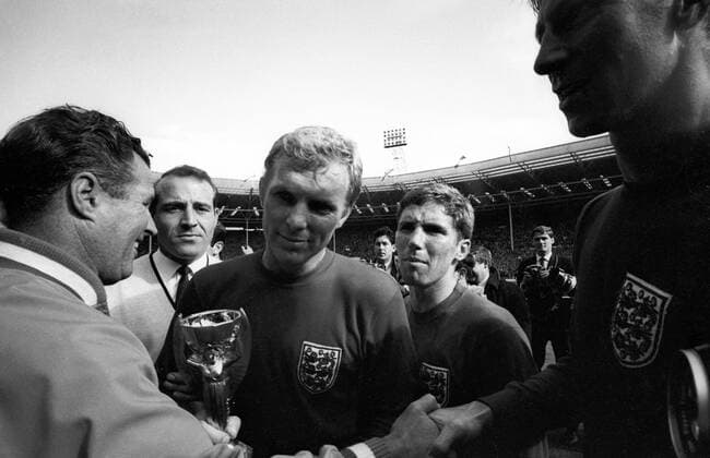 Bobby Moore (England, Mitte) bekommt nach dem Sieg im Finale der WM 1966 den Coupe Jules Rimet überreicht Jubel, Freude Sieg Weltmeister Aufmacher Siegerehrung Nationaltrikot