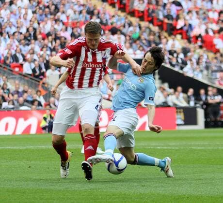 Manchester Citys David Silva tussles with Stokes Robert Huth EON FA Cup Final Manchester City (blue) v Stoke City (red white) 14th May, 2011 EDITORIAL USE ONLY. No use with unauthorised audio, video, data, fixture lists, club league logos or live services. Online in-match use limited to 120 images, no video emulation. No use in betting, games or single club league player publications.
