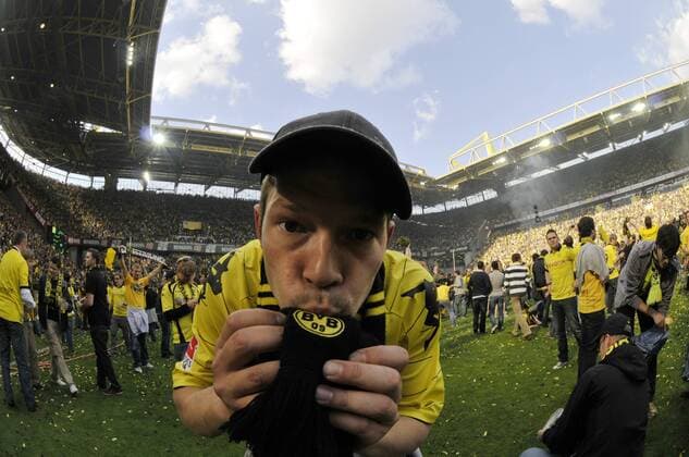 Fussball-Bundesliga, 34. Spieltag, Signal Iduna Park, Borussia Dortmund (gelb) - 3:1, Meisterfeier der Fans auf dem Rasen --- Fan küsst seinen BVB-Schal auf dem Spielfeld des Dortmunder Stadions o0 Freude Jubel Zuschauer Schal, Fanschal Logo, Emblem, Vereinslogo, Vereinsemblem