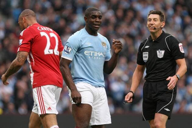Football - Premier League - Manchester CIty vs. Stoke City Referee Lee Probert checks on a dazed Micah Richards of Manchester City after he blocks a shot with his head at the City of Manchester Stadium 