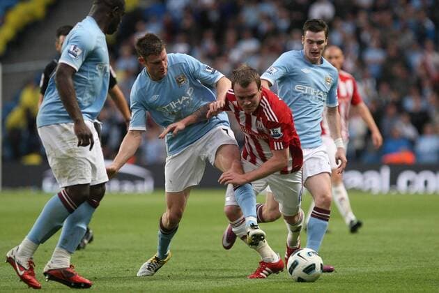 Football - Premier League - Manchester CIty vs. Stoke City James Milner of Manchester City challenges Stoke s Glenn Whelan at the City of Manchester Stadium 