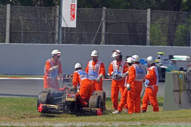Streckenposten neben dem havarierten Rennwagen von NICK HEIDFELD (GER) - LOTUS RENAULT -  GillesLevent o0 Unfall, Crash, Aus, Ausfall Objekte Wrack