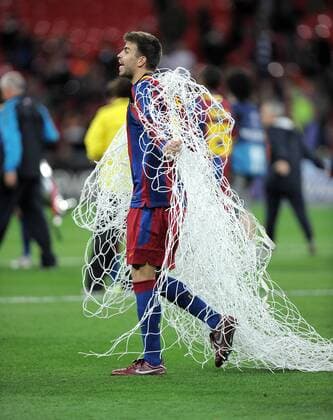 FUSSBALL CHAMPIONSLEAGUE FINALE SAISON 2010 2011 28.05.2011 FC Barcelona - Manchester United FC Champions League Sieger 2011: FC Barcelona feiert den Sieg Gerard Pique (Barca) schneidet das NETZ aus dem TOR und legt es um sich  o0 Tornetz Objekte Souvenir