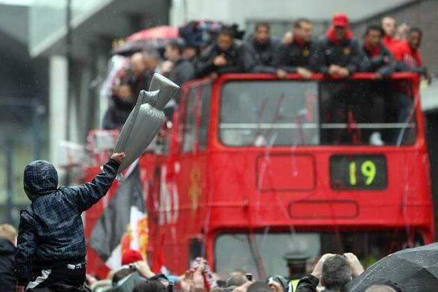 Football - Manchester United ManU Premier League Champions Parade A young fan holds up an inflatable trophy as the team bus passes on Deansgate, Manchester  o0 Autokorso Bus Objekte Meister Meisterschaft Feier Meisterfeier