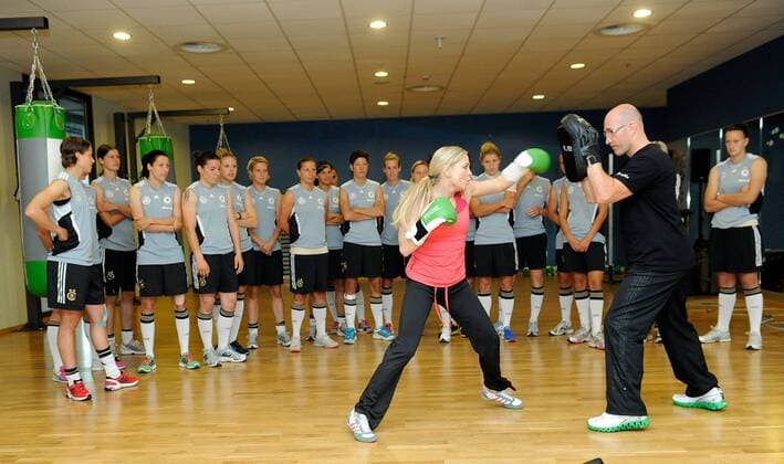FRANKFURT AM MAIN, GERMANY - JUNE 13: Former wolrd boxing champion Regina Halmich is boxing with the German National Football Team during a Germany training session at Fitness First club on June 13, 2011 in Frankfurt am Main, Germany. 