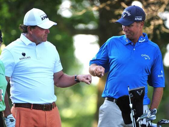 Phil Mickelson pounds fists with his caddie Jim MacKay on the 4th tee box during a practice round prior to the U.S. Open at Congressional Country Club in Bethesda, Maryland on June 14, 2011.  WAP20110614302