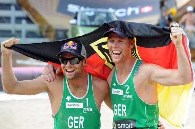 BEACHVOLLEYBALL - FIVB WM 2011 ROM,ITALIEN,19.JUN.11 - DIVERS, BEACH VOLLEYBALL - FIVB Weltmeisterschaften, Herren. Bild zeigt den Jubel von Julius Brink und Jonas Reckermann (GER). Keyword: Fahne. 