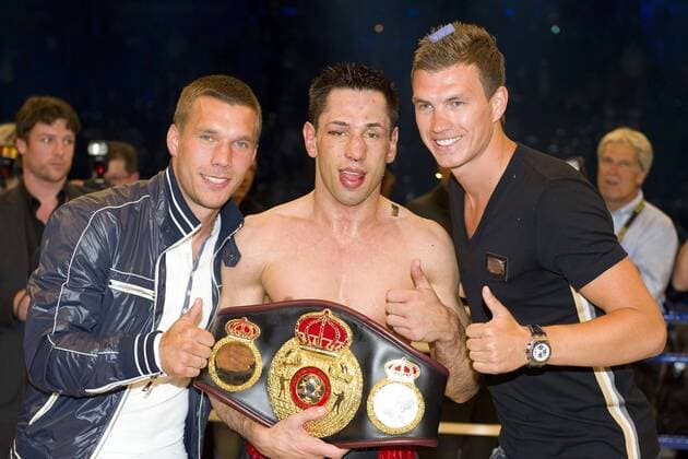 Lukas PODOLSKI ( 1. FC Köln, Deutschland, li.), Felix STURM (GER, mi.) und Edin DZEKO (Manchester City, Bosnien) mit WM Guertel (Gürtel), Jubel, jubeln, Freude, cheers, halbe Figur, Halbfigur, Querformat, Mittelgewichts-WM (WBA) am 25.06.2011 in Koeln, o0 privat BL Premier League Trophäe Weltmeistergürtel Objekte Weltmeister Sieg