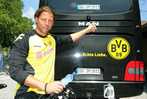 Sonntag 10.07.2011, 1. Bundesliga Saison 11 12 - BVB Borussia Dortmund im Trainingslager in Bad Ragaz, Torwart Roman Weidenfeller (BVB) zeigt auf die neuen Kennzeichen DO DM 2011 - DeFodi018 o0 Objekte Bus Heck Logo Vereinslogo Schriftzug Echte Liebe