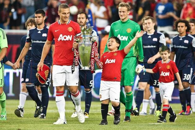 July 13, 2011 - Foxborough, Massachuestts, U.S - Manchester United forward Nemanja Vidic (15) leads the team onto the field carrying the Barclays Premier League Cup prior to the friendly match against the New England Revolution. Manchester United defeated the New England Revolution 4 - 1. MLS Fussball Herren USA 2011- July 13 - New England Revolution vs Manchester United (ManU) - ZUMAx25 o0 Pokal Trophäe Objekte Kind