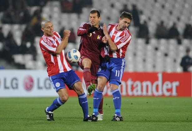 Alejandro Moreno(c) de Venezuela , disputa el balon con Dario Veron(i) y Jonathan Santana(d) de Paraguay, Venezuela - Paraguay, Mendoza 