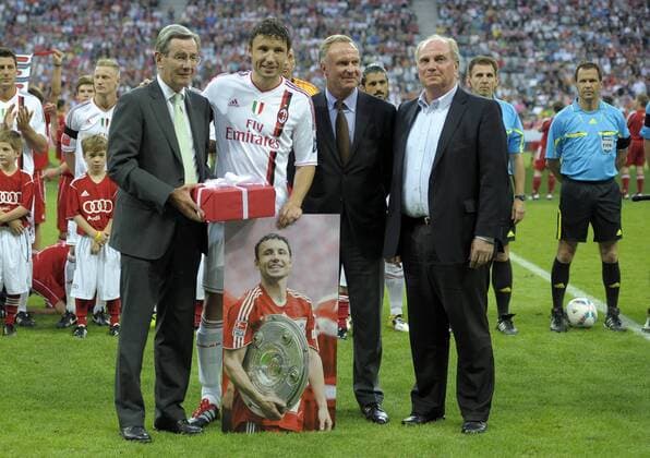 26.07.2011, Fussball Audi Cup 2011: FC Bayern München - AC Mailand, in der Allianz-Arena München. Mark van Bommel (2.v.li , Mailand), Vorstandsvorsitzender Karl-Heinz Rummenigge (2.v.re, München) und Geschäftsführer Karl Hopfner (li, Bayern München) und Präsident Uli Hoeneß (re, München). o0 Abschied, verabschieden, Verabschiedung, Vereinswechsel Geschenk