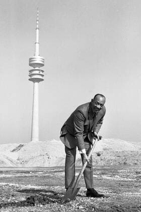 Jesse OWENS, USA, Leichtathlet, Sprinter, Weitspringer, Weitsprung, hier beim Olympiatreffen in München am 08.03.1969, SW-Aufahme, führt den ersten Spatenstich am Olympiagelände München aus, im Hintergrund der Fernsehturm, o0 Leichtathletik Olympiaturm