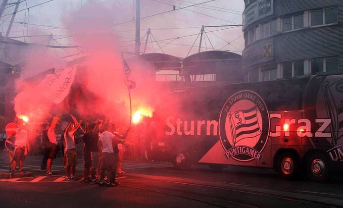 FUSSBALL - UEFA CL Quali, GRAZ,AUSTRIA,03.AUG.11 - FUSSBALL - UEFA Champions League, Qualifikation, SK Sturm Graz. Bild zeigt den Mannschaftsbus von Sturm und Fans. Keywords: Bengalisches Feuer, Rauch, Fahnen. 