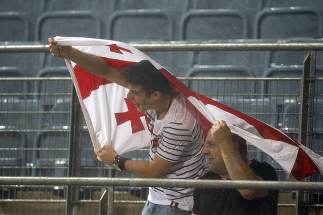 FUSSBALL - UEFA CL Quali, League, FC Zestafoni. Bild zeigt Fans von Zestafoni. Keywords: Fahne, Regen.  o0 Regenspiel Nässe nass Wetterverhältnisse Witterung