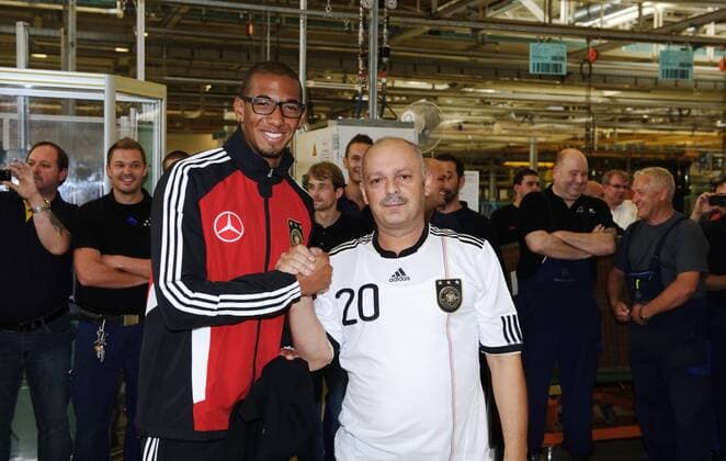 Jerome BOATENG (li. Deutschland) beim Trikottausch mit einem Mitarbeiter von Mercedes-Benz. Werksführung der deutschen Fussball Nationalmannschaft im Motorenwerk von Mercedes-Benz in Bad Cannstatt Stuttgart am 9.8.2011.
